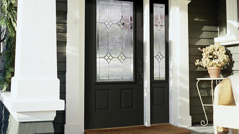 A black steel entry door with custom glass insert and right sidelite.
