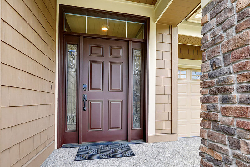 Mahogany steel entry door with modern, decorative glass sidelites and a square grille transom.