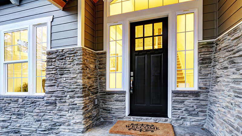 A modern black front door with rectangular glass insert.