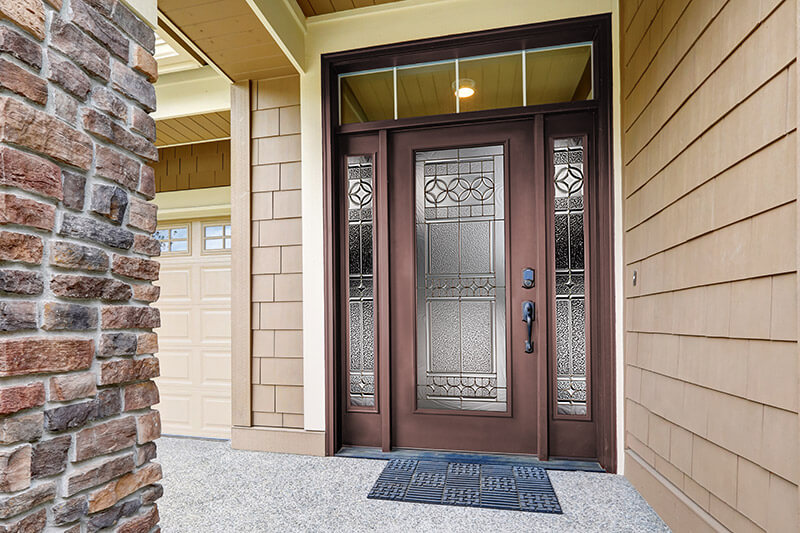 A modern, commercial brown steel entry door with full glass sidelites and custom, rectangular transom.