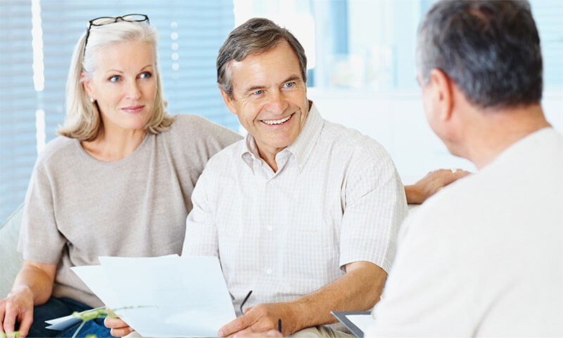 An elderly couple getting a quote on replacement windows for their home.