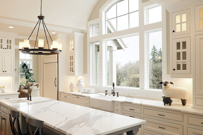 Vinyl replacement windows above a kitchen sink in a modern, refinished kitchen.